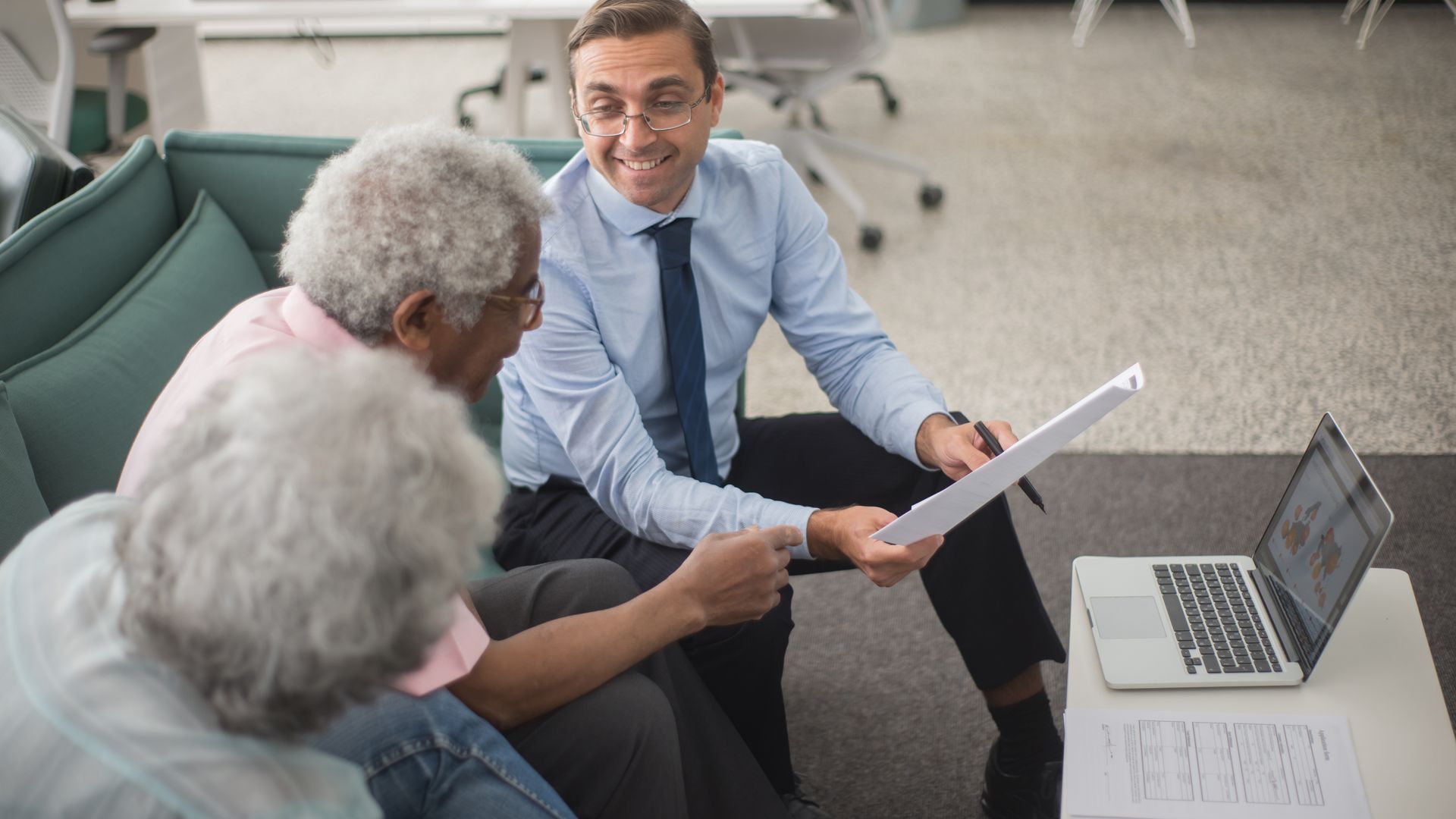 Conseiller en gestion de patrimoine expliquant la donation avant cession à un couple senior